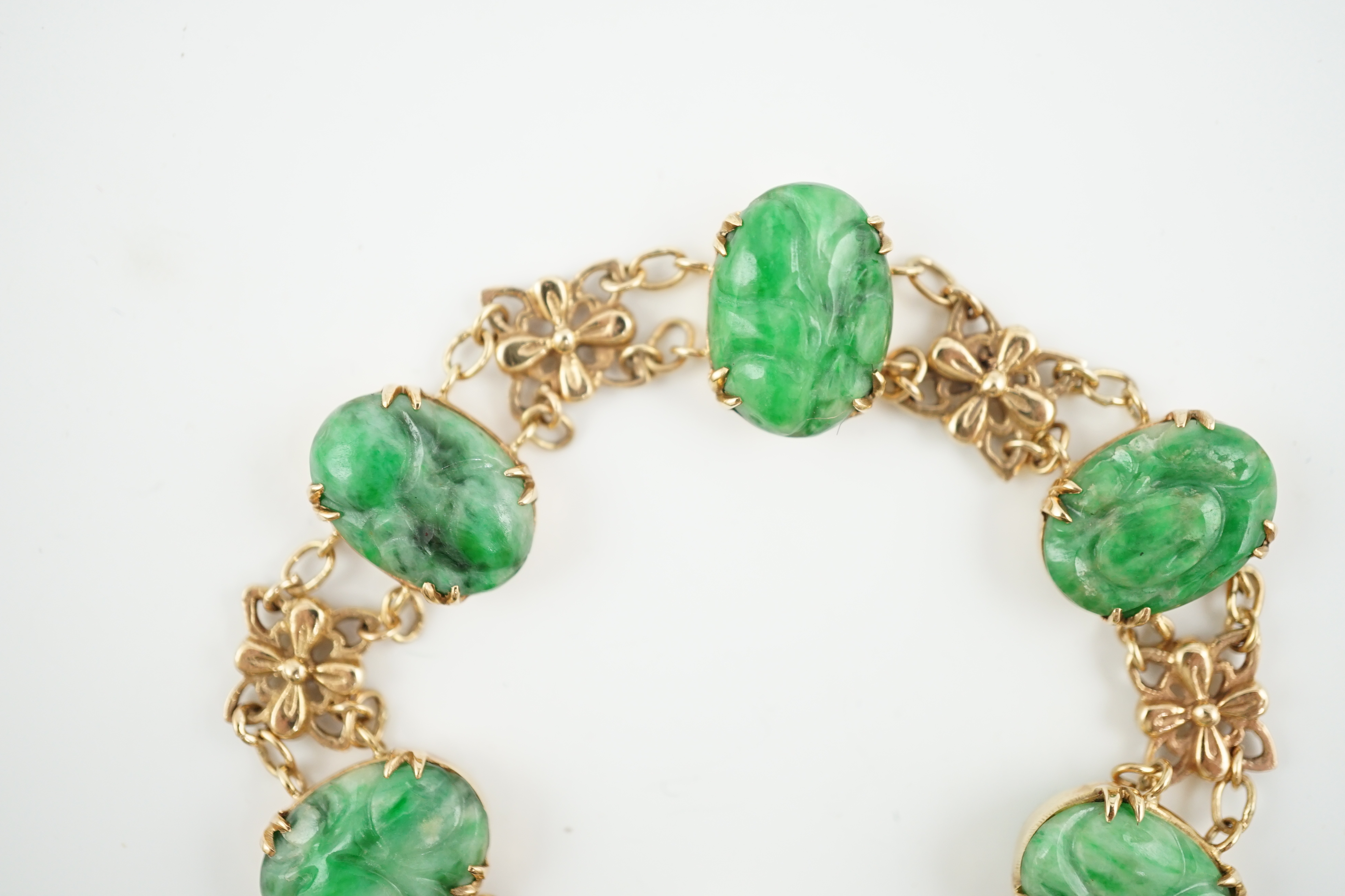 An early 20th century 9ct gold butterfly link and six stone carved jade set bracelet